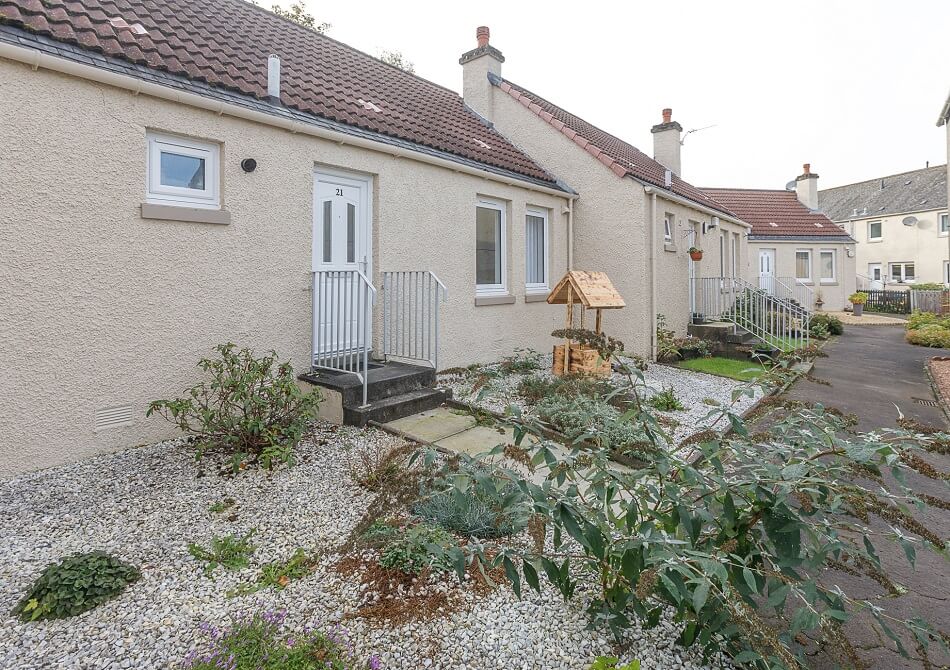 Example of one of the bungalows at Castle Park, with steps to front door and garden ornaments.