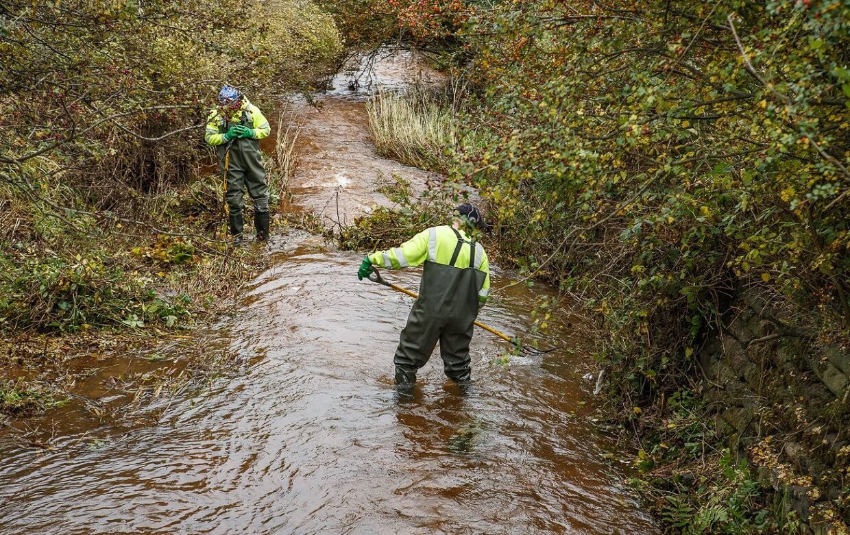 Men clearing debris from burn