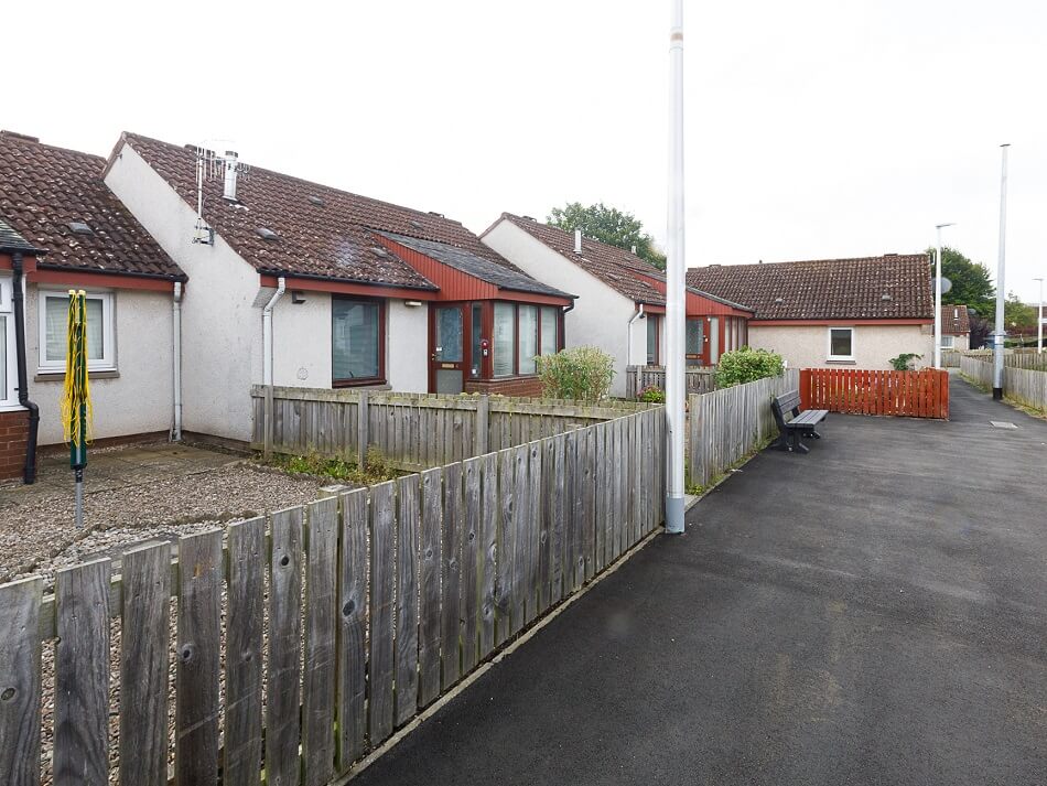 Exterior of the bungalows at Bonvil Row, showing individual gardens