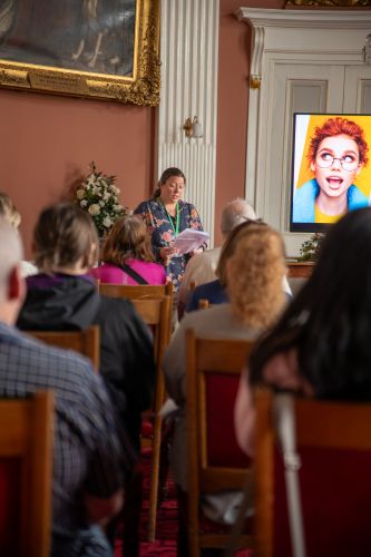 Woman presenting to seated audience at event - North East Fife adult learners celebrated at inspiring community event