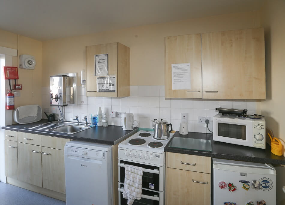 Communal kitchen area at Ross Gardens, with cooker, fridge and food prep area