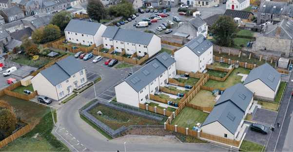 Aerial view of completed houses at Valley House, with grey pitched roofs and white facade. Aerial view of completed houses at Valley House, with grey pitched roofs and white facade.