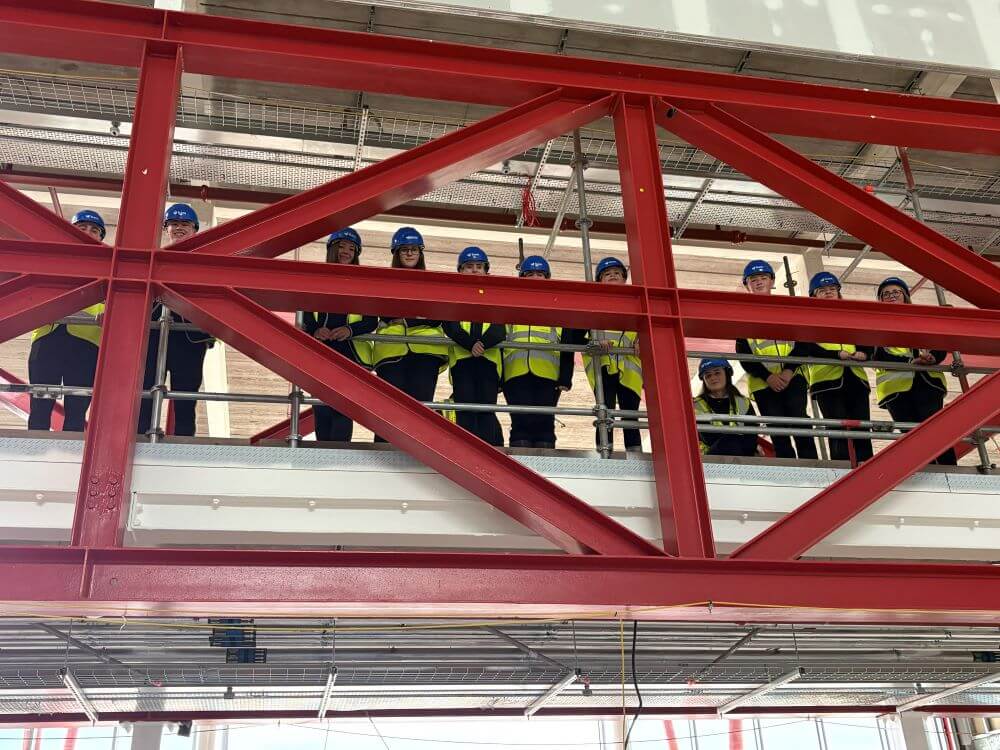 Pupil visit to Caledonia High School Pupils wearing hard hats standing on the bridge at new Caledonia High School