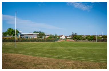 A rugby pitch with a building in the background A rugby pitch with a building in the background