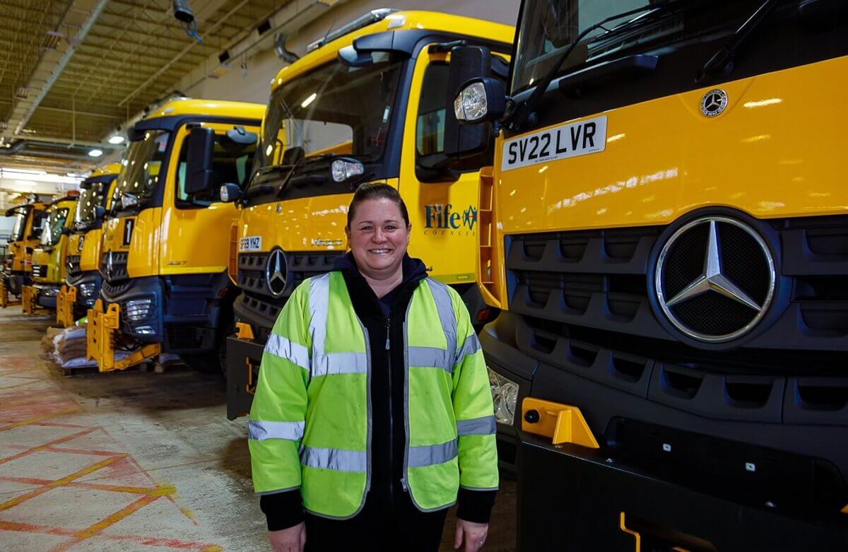 Jennifer is familiar with most of Fife's gritting routes and can be working on standby before she starts her office shift. gritter driver in front of gritting lorries