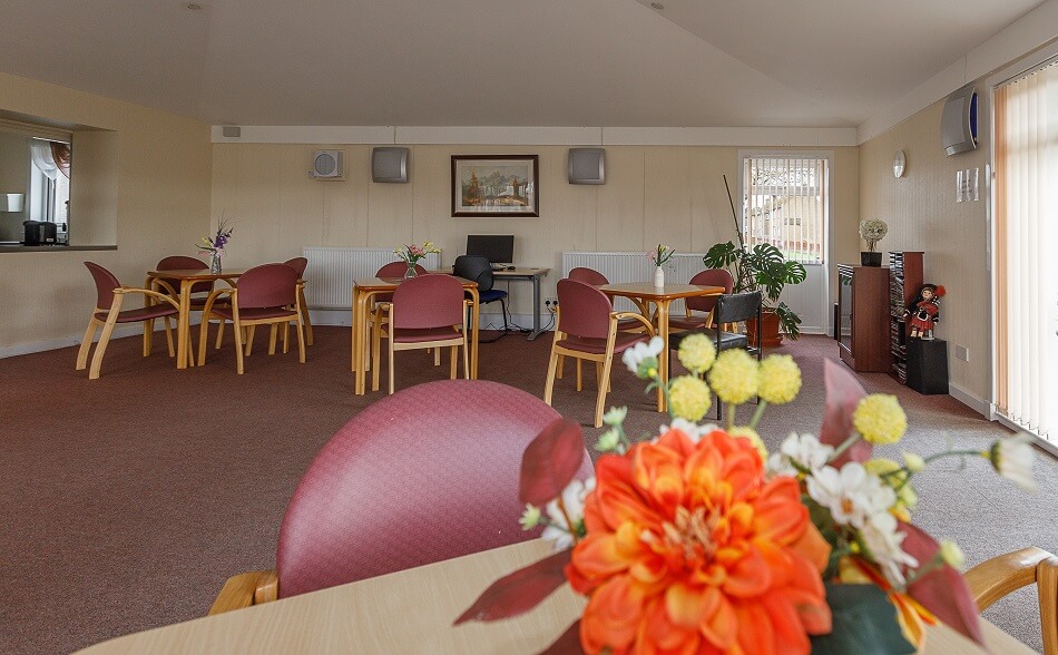 Seating area at Graham Court, with individual tables and chairs of four