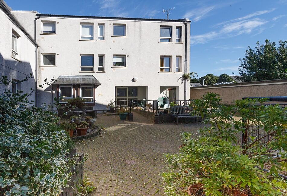 Exterior of Bathgate Court, with seating areas and shared walkway