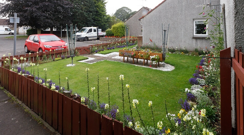 Example of shared garden, with rotary clothes driers and grassy area with flowers