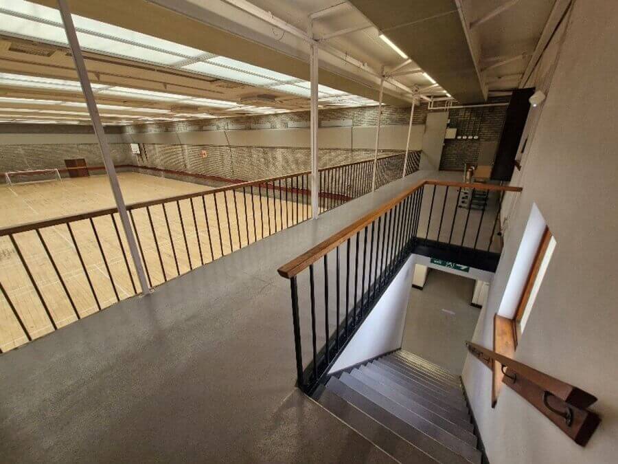 balcony view A balcony view of the games hall. Stairs lead down to the floor. A railing separates the levels