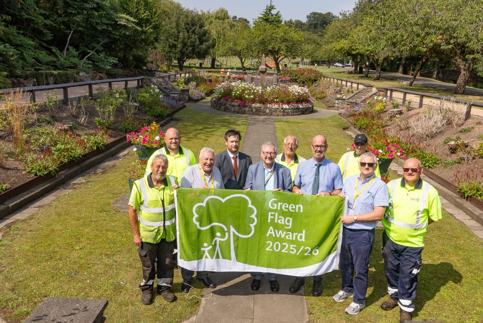 Letham Glen Green Flag Councillors and staff holding the Green Flag award flag with Letham Glen's beautiful and colourful sunken garden in the background