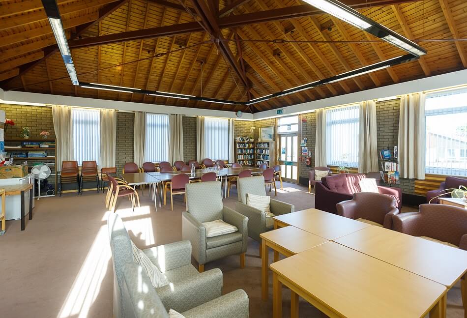 Communal seating and dining area at Scooniehill, with wooden peaked ceiling as a feature
