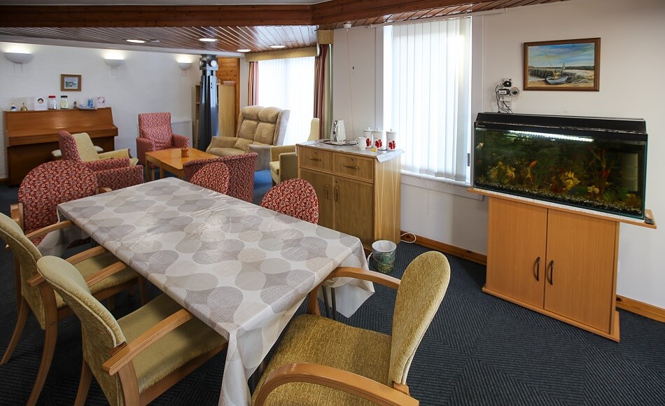 Communal dining and seating area at Harbourlea, with fish tank