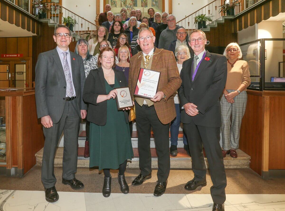 Group of people watching the presentation of a certificate and award