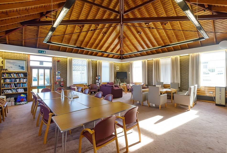 Communal seating and dining area at Scooniehill, with wooden peaked ceiling as a feature