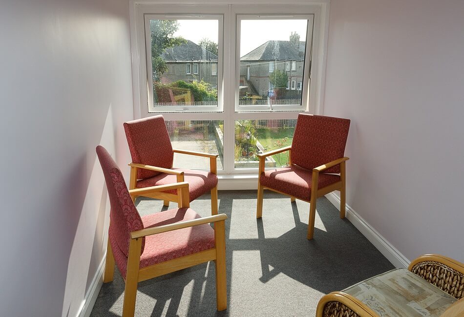 Small seating area next to large window, overlooking the communal garden