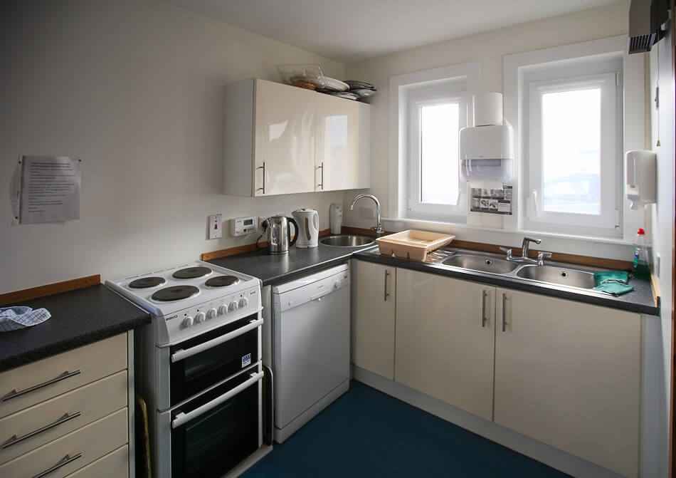 Communal kitchen area at Harbourlea, with sink and cooking area