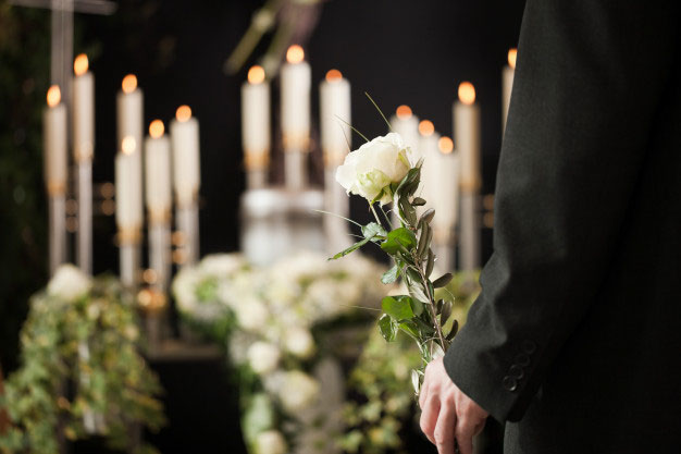 man holding rose at funeral