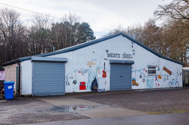 Funding approved for Glenrothes Men’s Shed extension Exterior of a Men’s Shed building with murals of tools, a guitar and workshop items.