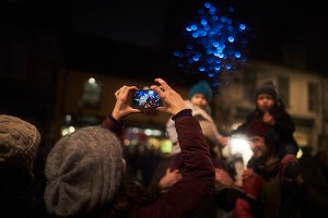 Crowd of people watching and taking photos of fireworks