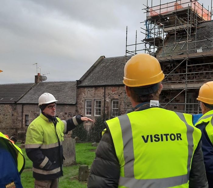 Attendees observe lime mortar restoration work at a previous hard hat tour of the Inverkeithing Town House - Learn all about the engineering transformations at Inverkeithing Town House