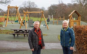 Play park at Ravenscraig with new play equipment in the background. Two men in the foreground. - Newly refurbished play area in Ravenscraig Park officially open