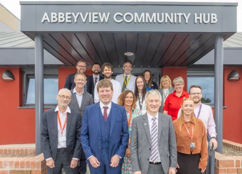 People standing outside community centre with plaque that was unveiled. - Ministerial visit highlights progress of Dunfermline New City Assembly