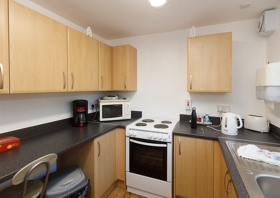 Communal kitchen with cooking facilities and meal prep area