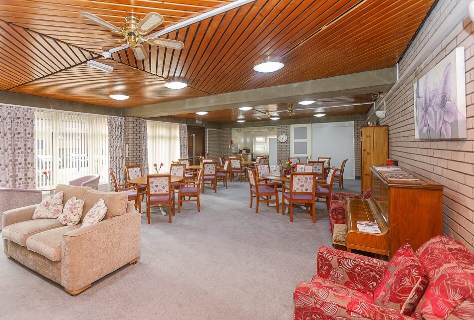 Dining and lounge area at Spencer House, with piano and armchairs