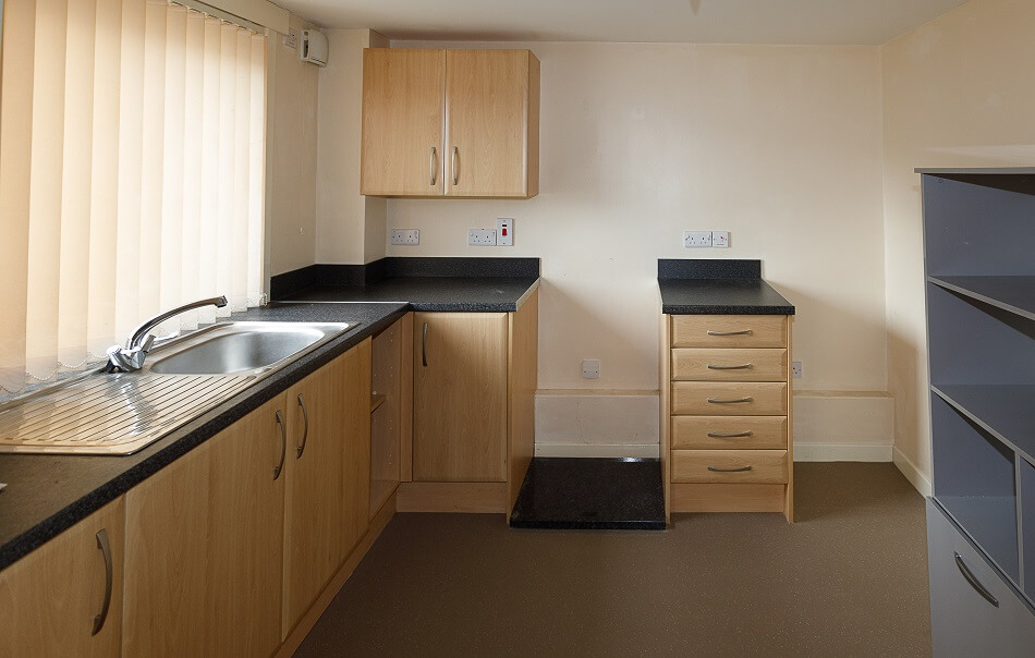 Kitchen within individual property at Byron Court, with sink and table prep area