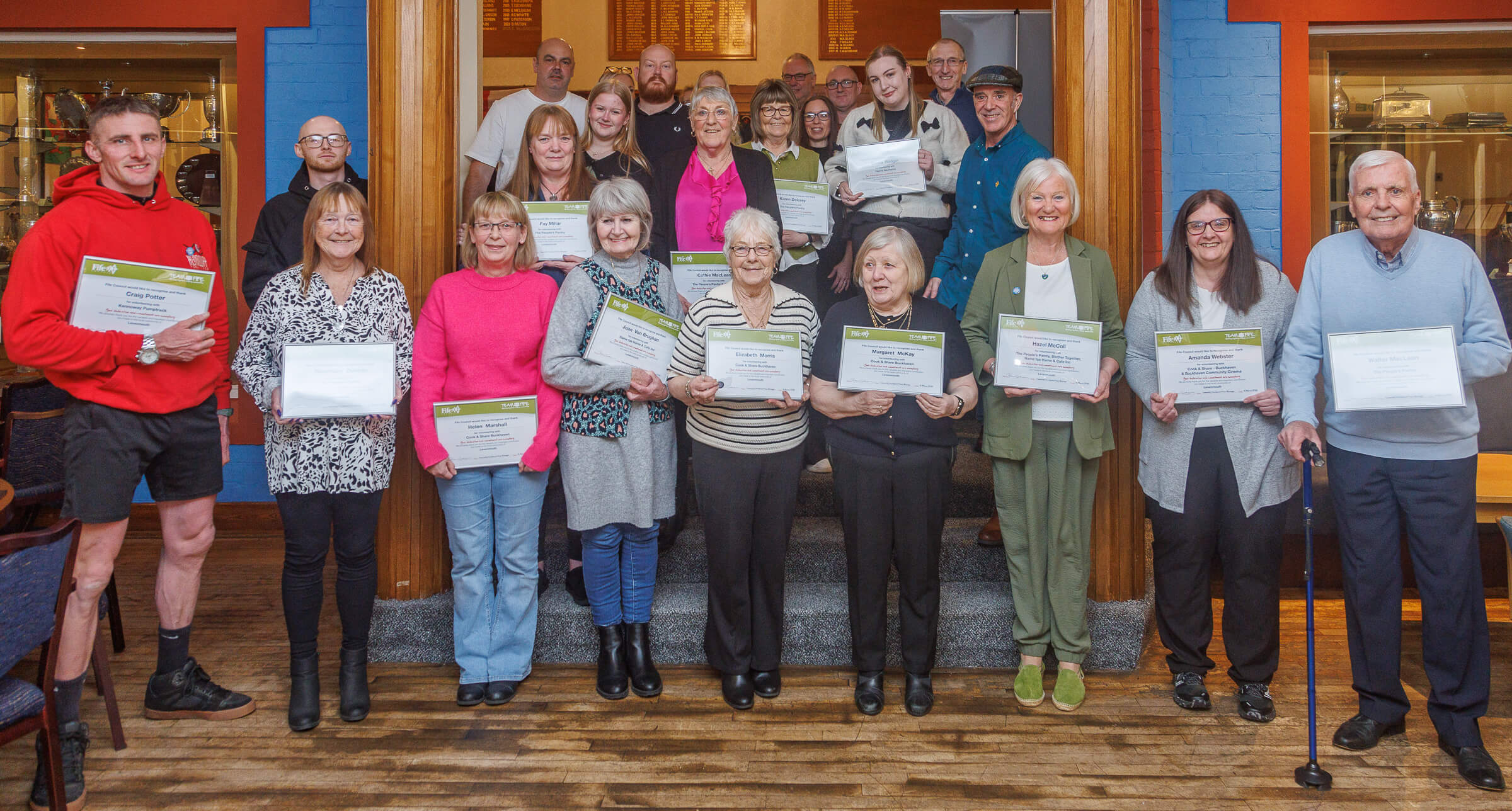 Volunteers from Levenmouth standing holding their certificates at the celebration event they attended