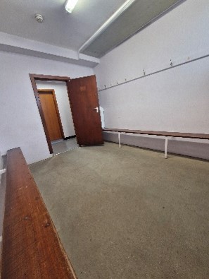 A small, empty changing room. Benches line the walls. A small, empty changing room. Benches line the walls.