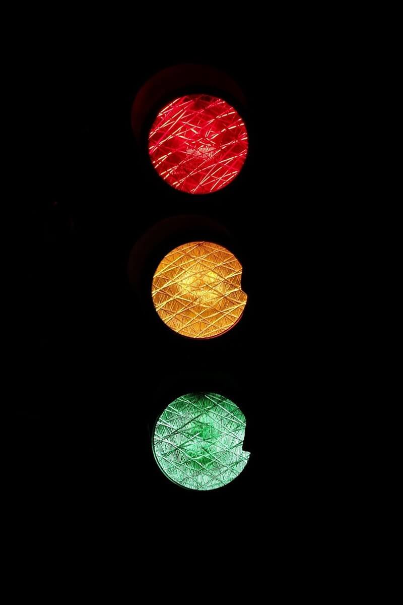 A brightly lit traffic signal stands out against the night sky.