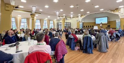 Attendees at the Fife COP conference listen and watch a presentation