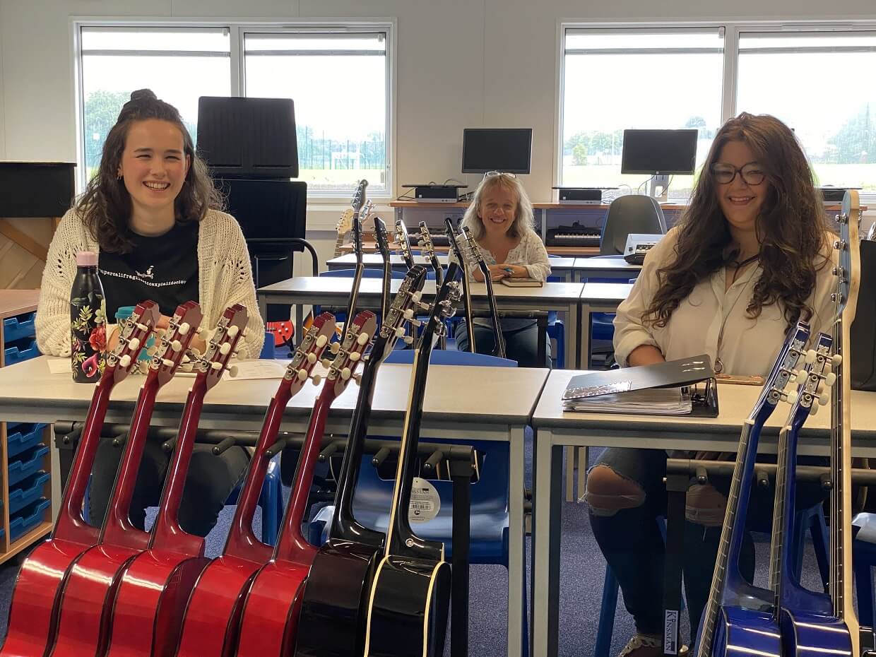 Pupils sitting at desk with Guitars in front of them