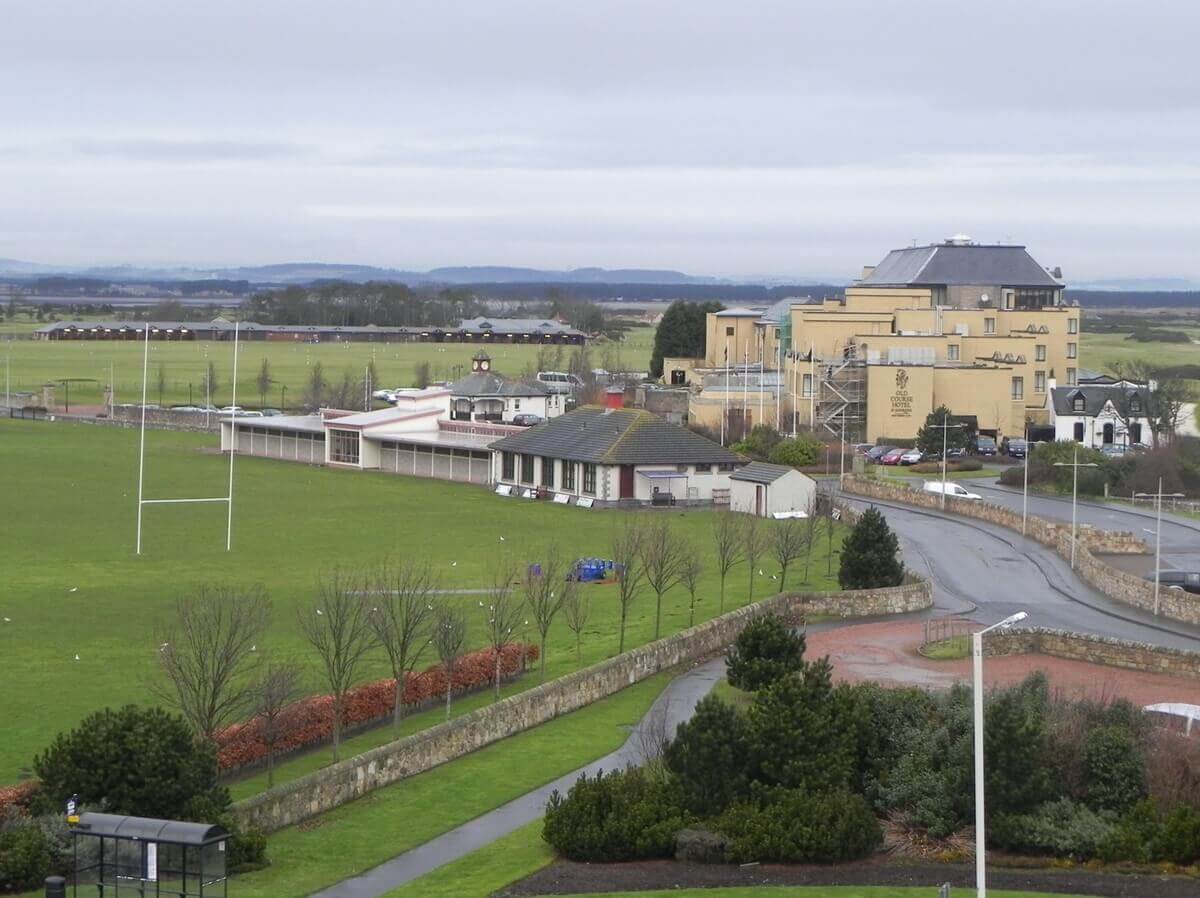 A ground-level view of a paved school campus walkway labelled with white road markings for a 