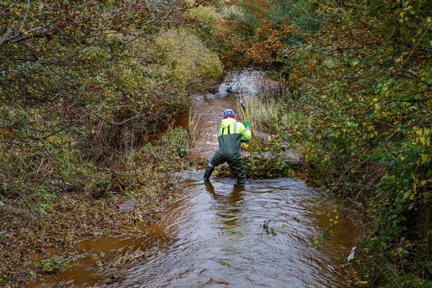 person clearing out river