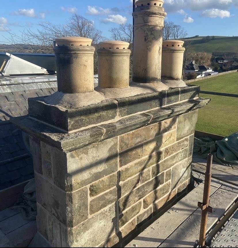 A chimney being repaired using traditional building skills A chimney being repaired using traditional building skills