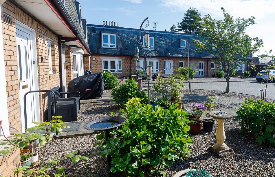 Front garden at a property at Melville Court, with seating and plants