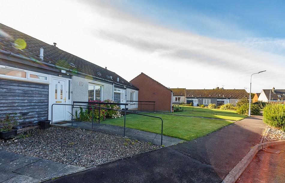 Exterior of the front of the white bungalows at Scooniehill, with ramp access