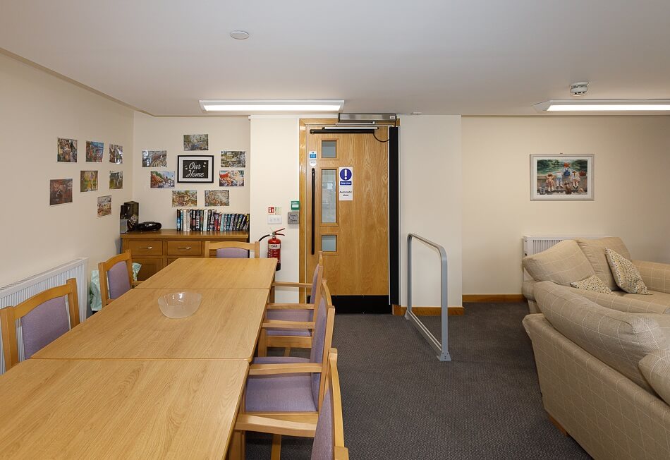 Communal dining area at Den Court, with reading corner