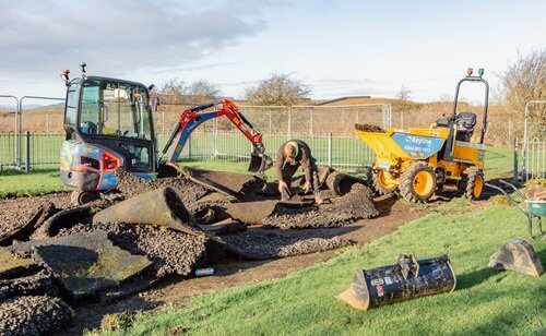 Work begins on Denfield Avenue play area, Cardenden Red digger and yellow dumper truck sitting on rolls of grass turf