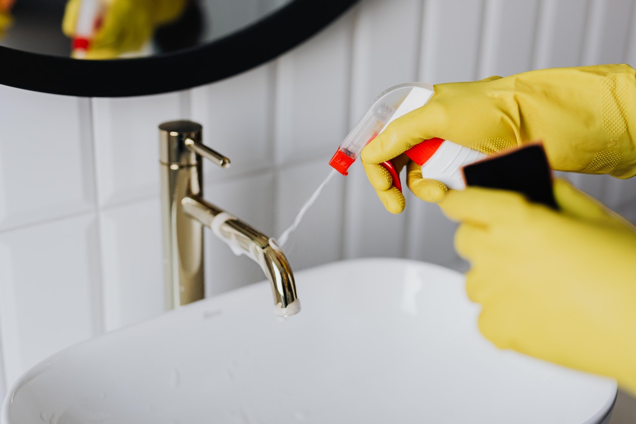 putting a cleaning spray on the faucet - Council scrutiny commends work of environmental health