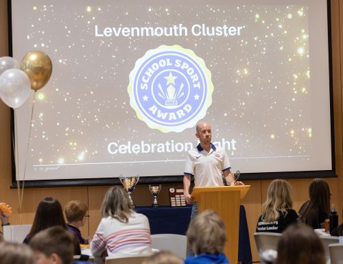 Man presenting to audience at event - Levenmouth Cluster comes together to celebrate Active Schools Gold Award success