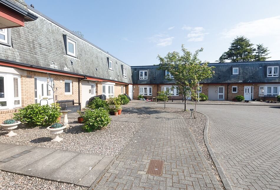 Exterior view of the bungalows at Melville Court, with gardens to the front