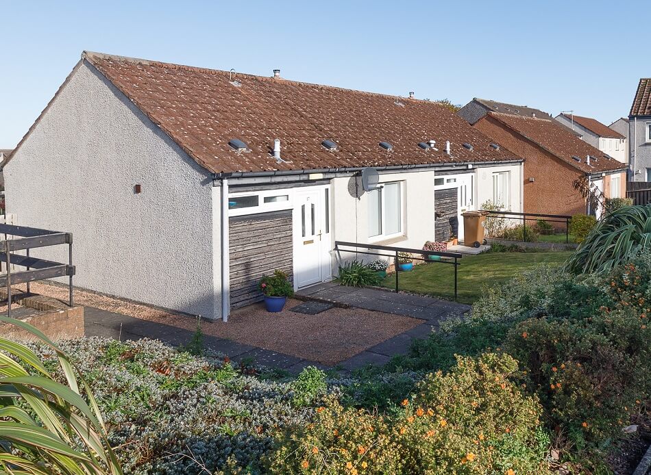 Exterior of the rear of the bungalows at Scooniehill, with small back garden