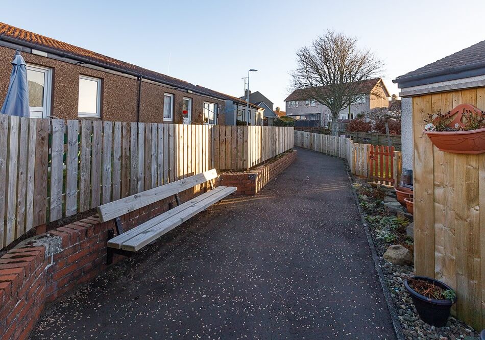 Exterior of the bungalows at The Riggs, with communal walkway and seating area