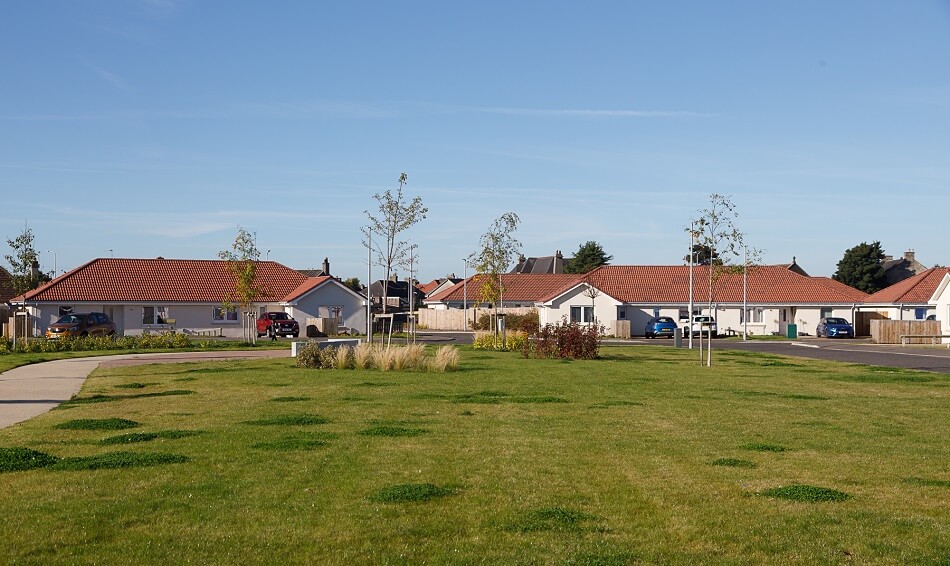 Large communal grassy area in front of the bungalows at Methil Care Village