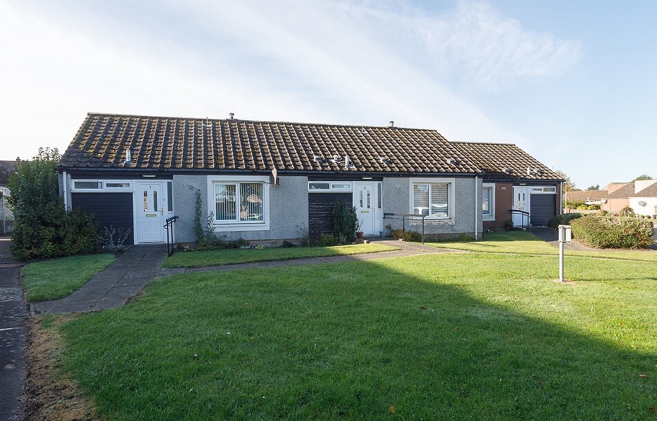 Exterior of the bungalows at Scooniehill, with communal grassy area to the front