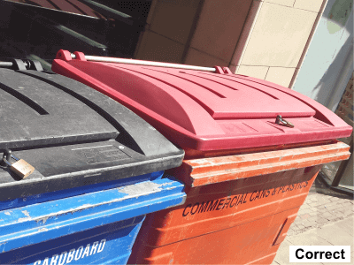 Image is of a commercial wheelie bin without rubbish overflowing and lid closed