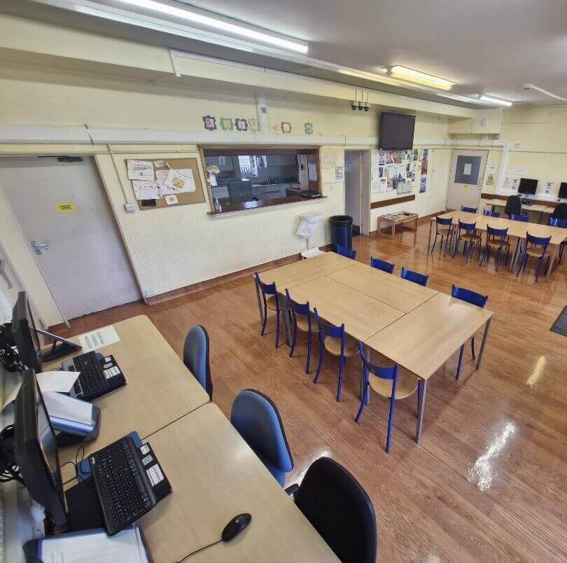 A large room with tables, chairs and computers A large room with tables, chairs and computers